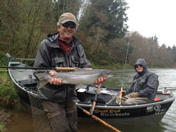 A client with a steelhead caught on a river on the Oregon Coast